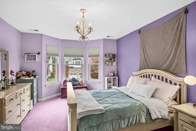 a bedroom with a bed dresser and window