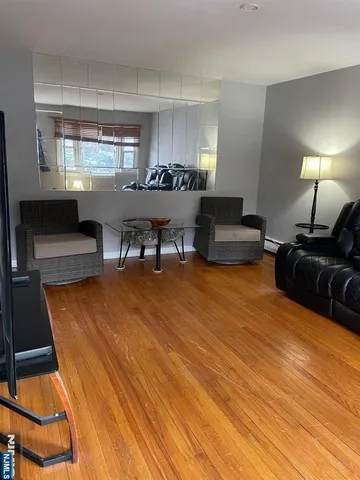 a living room with furniture a piano and a flat screen tv
