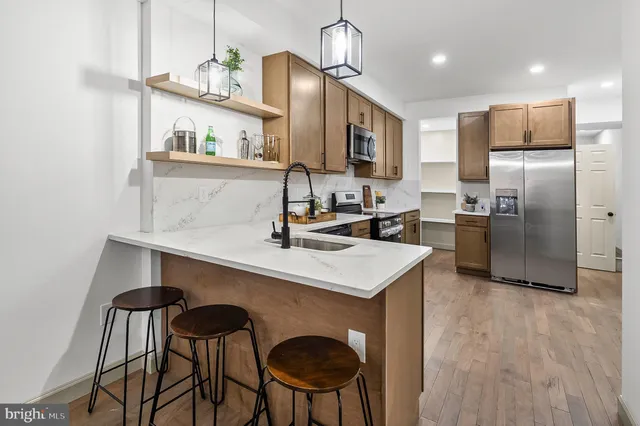 a kitchen with stainless steel appliances a sink and a refrigerator
