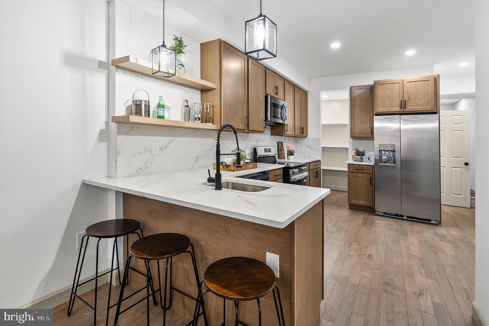2508 East Preston Street Baltimore, MD 21213 - Photo 6 of 29 a kitchen with stainless steel appliances a sink and a refrigerator