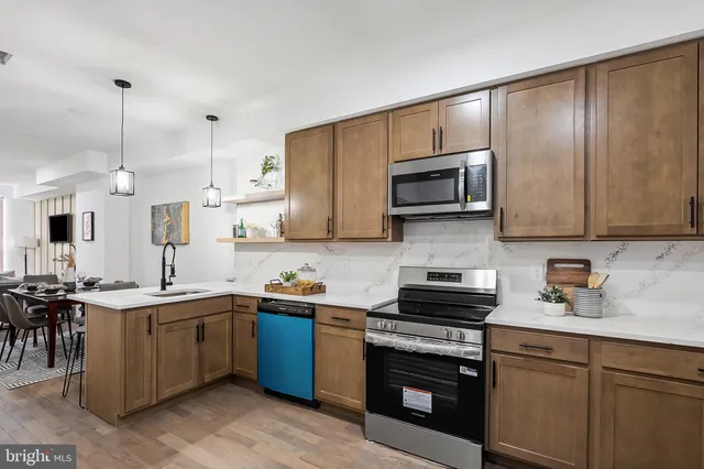 a kitchen with stainless steel appliances a stove sink microwave and cabinets