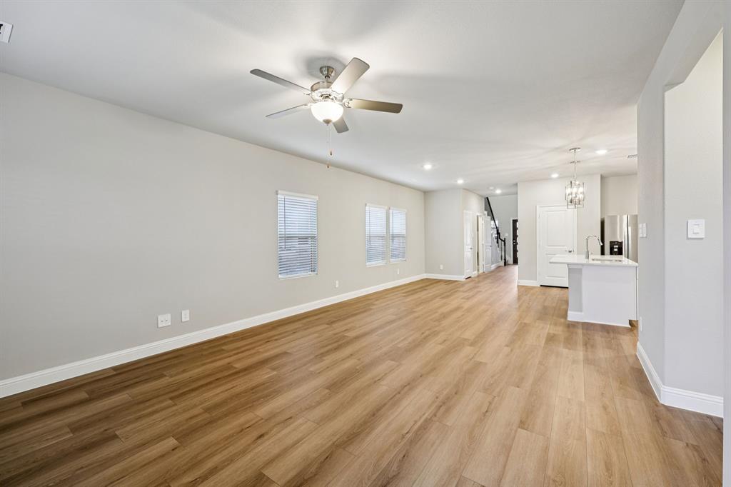 1721 Arches Road Anna, TX 75409 - Photo 11 of 39 a view of a room with wooden floor and kitchen view
