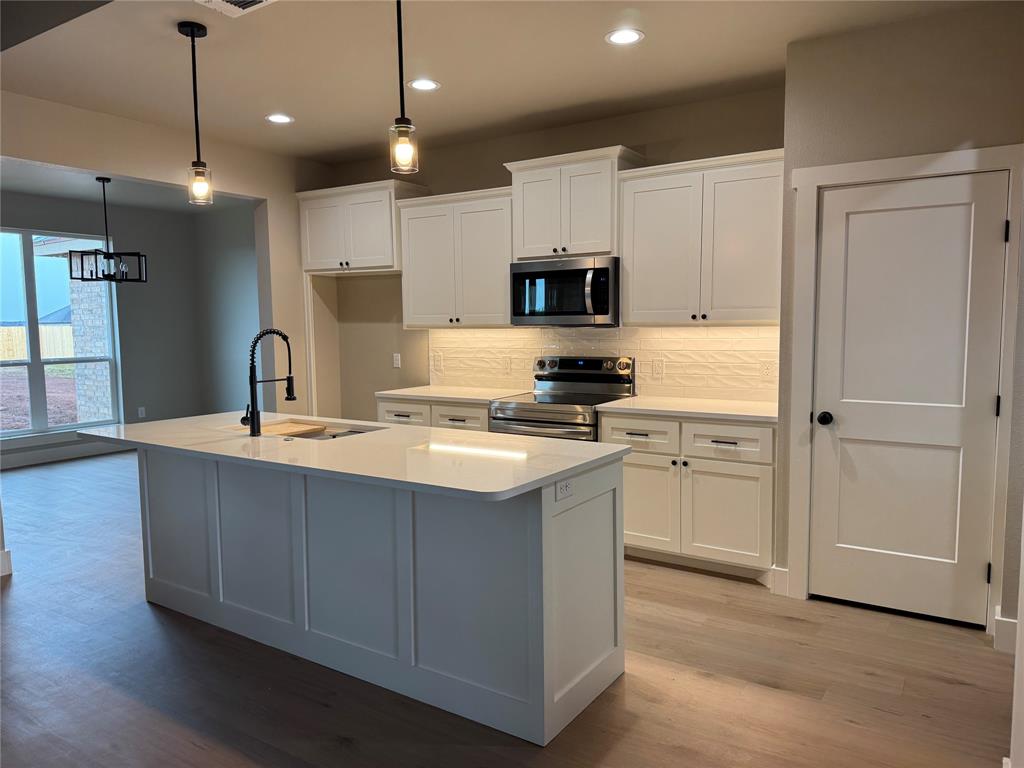 143 Ridge Road Tuscola, TX 79562 - Photo 5 of 24 a kitchen with kitchen island a sink stainless steel appliances and cabinets
