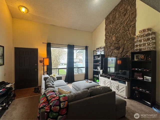 a living room with furniture a floor to ceiling window and a flat screen tv