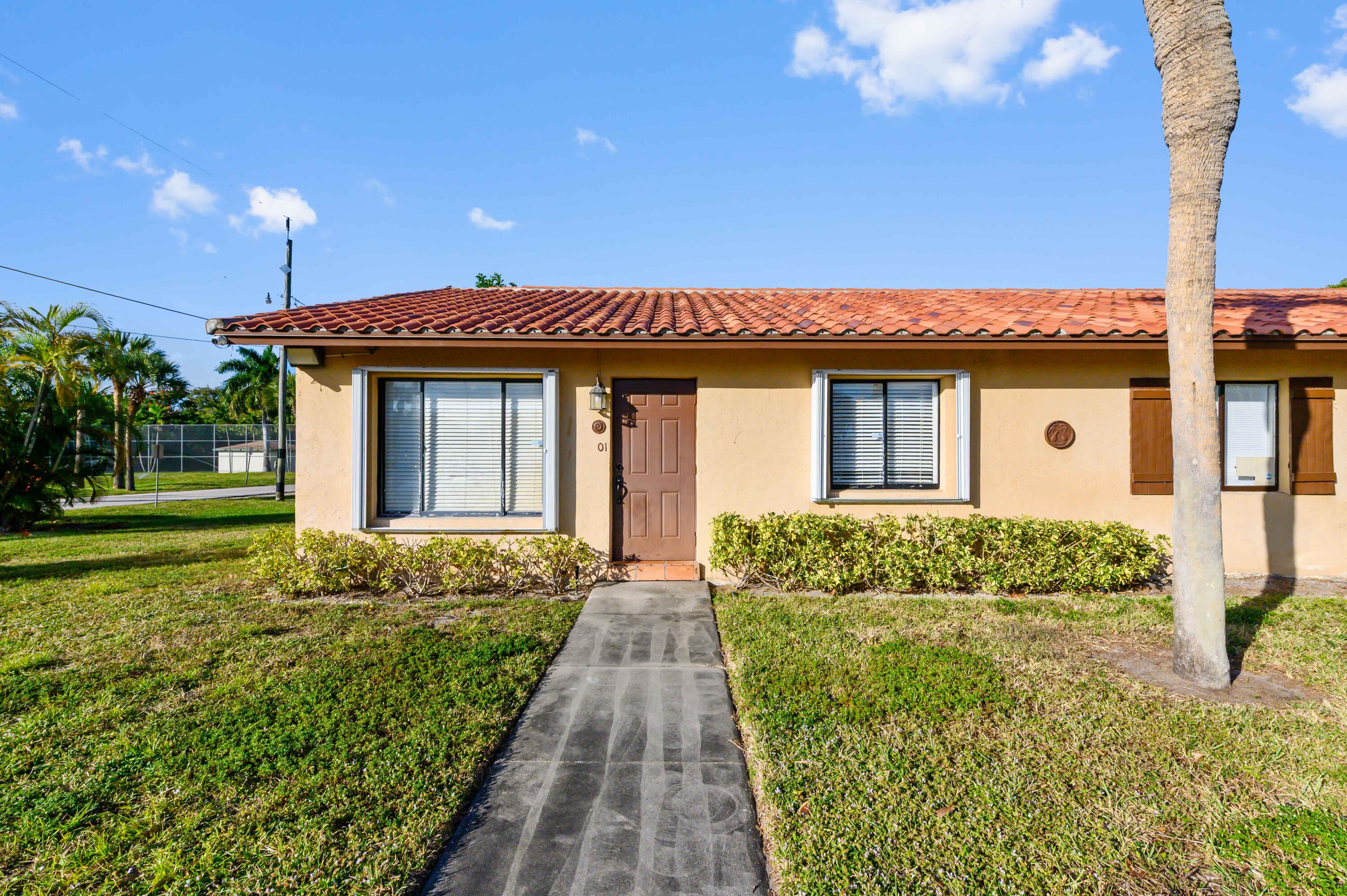 1100 Summer Street, Unit 1 Palm Springs, FL 33461 - Photo 1 of 34 a front view of a house with a yard