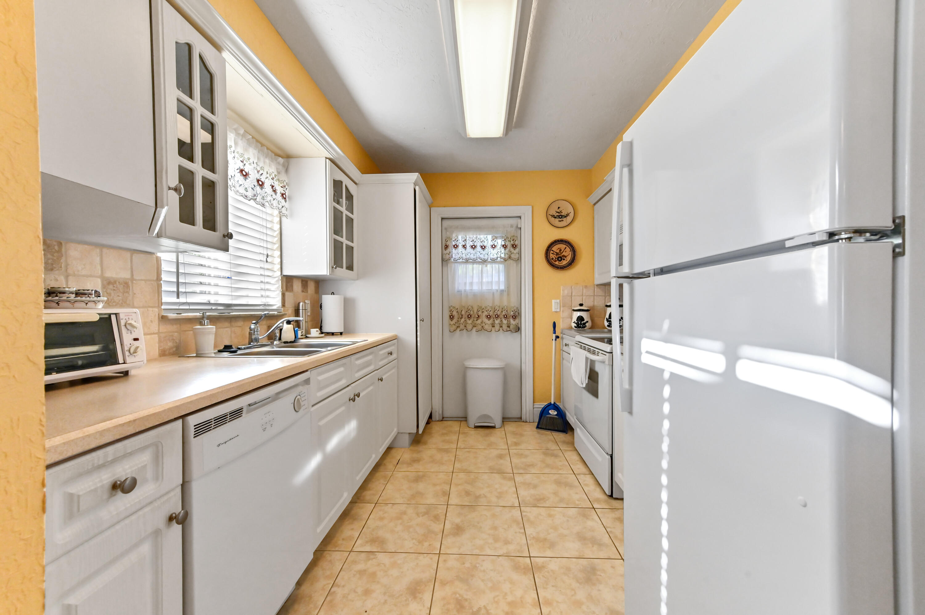 1100 Summer Street, Unit 1 Palm Springs, FL 33461 - Photo 11 of 34 a large white kitchen with a sink and refrigerator