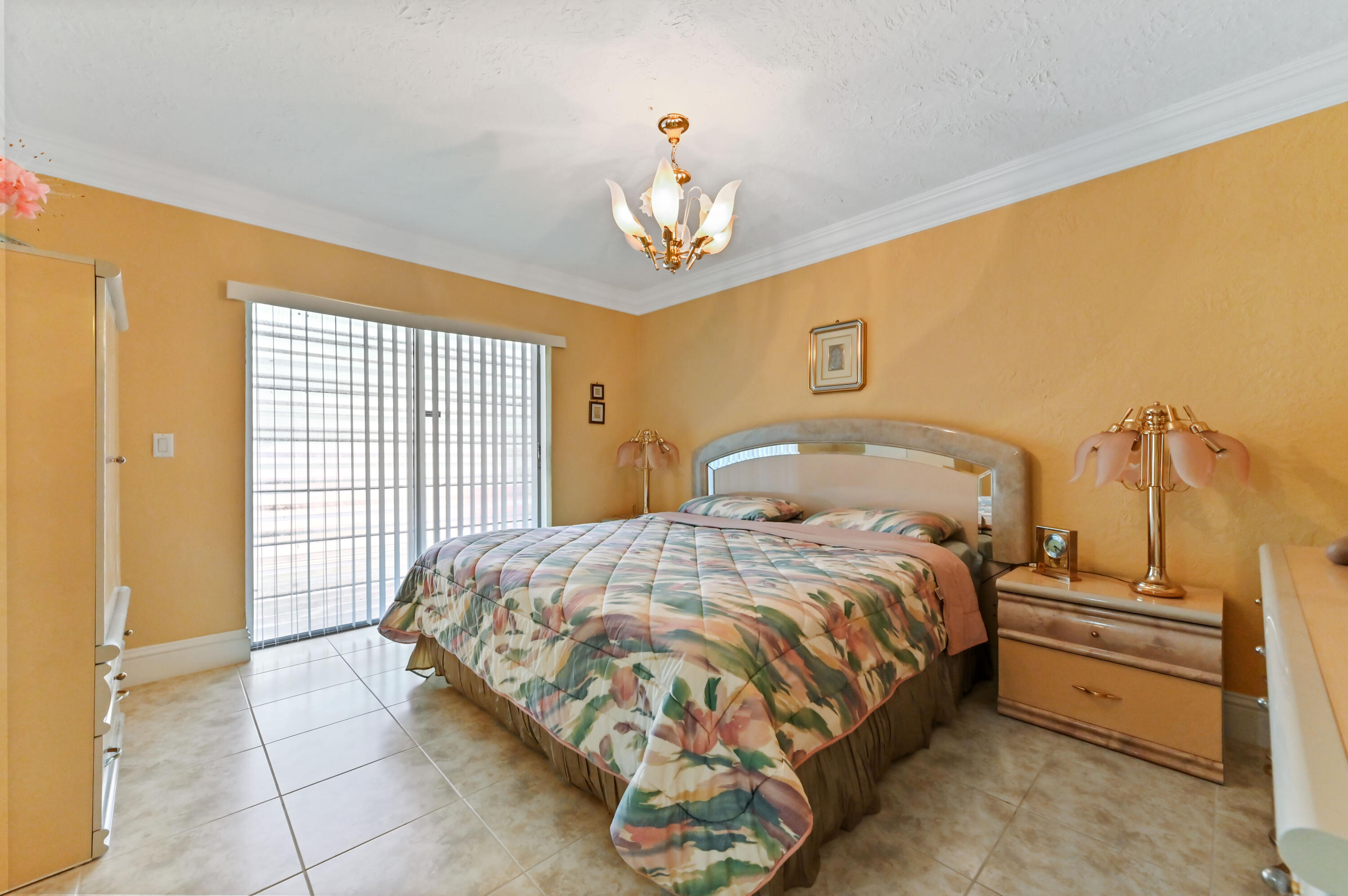 1100 Summer Street, Unit 1 Palm Springs, FL 33461 - Photo 13 of 34 a bedroom with a bed and a chandelier