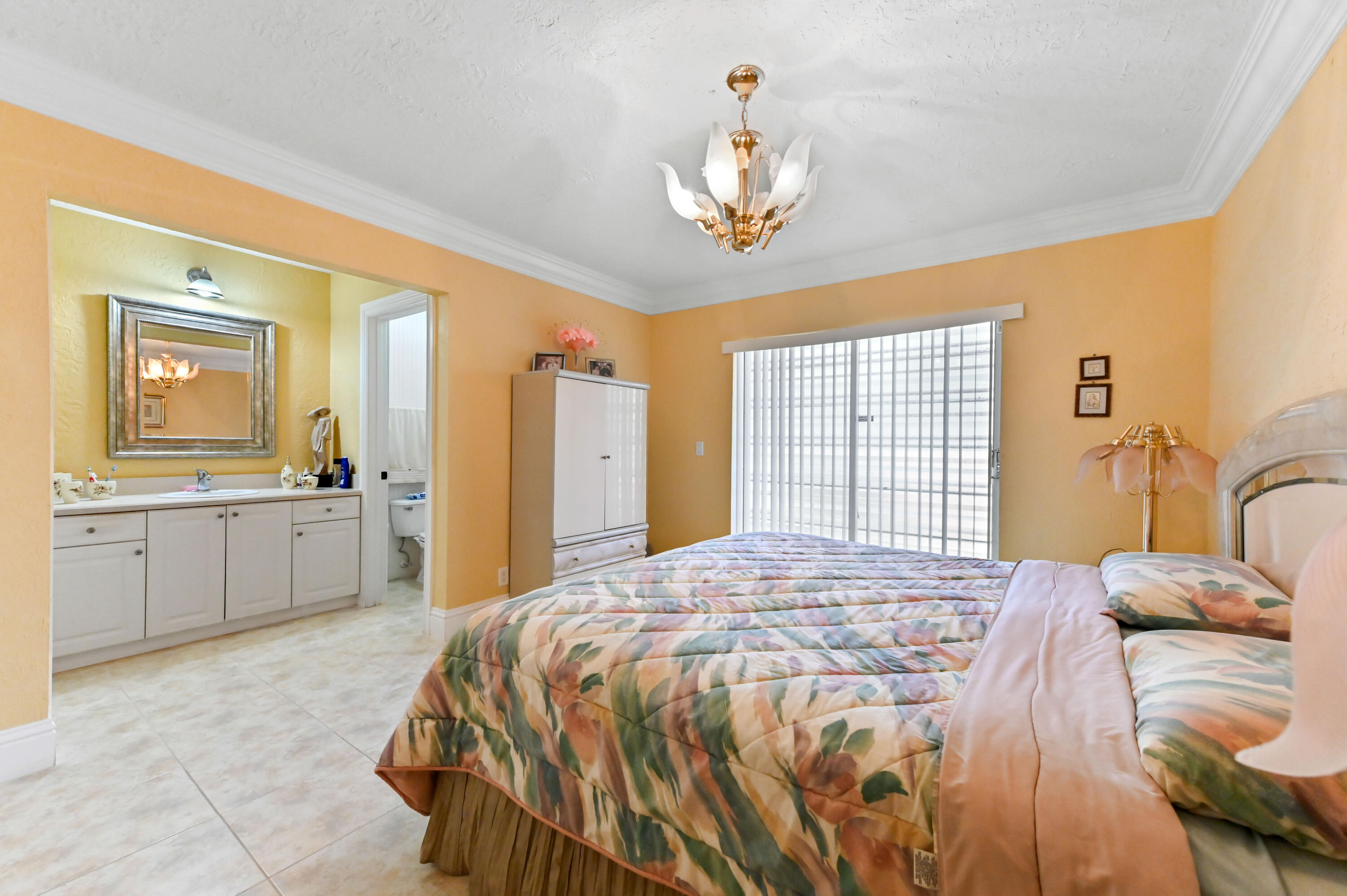 1100 Summer Street, Unit 1 Palm Springs, FL 33461 - Photo 14 of 34 a spacious bedroom with a large bed a chandelier and windows