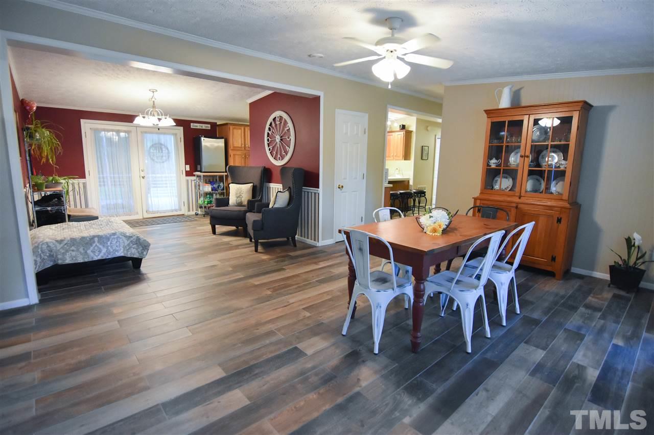 727 Ned Moore Road Timberlake, NC 27583 - Photo 2 of 24 a dining room with furniture a chandelier and wooden floor