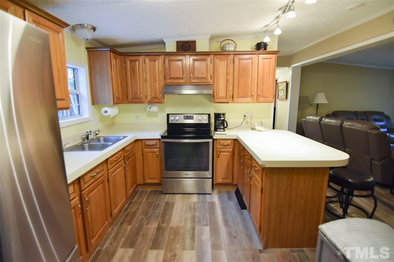 727 Ned Moore Road Timberlake, NC 27583 - Photo 11 of 24 a kitchen with a sink stove and refrigerator