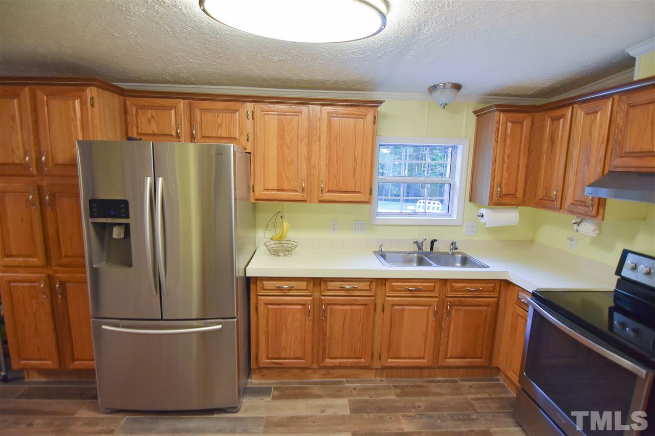727 Ned Moore Road Timberlake, NC 27583 - Photo 12 of 24 a kitchen with stainless steel appliances a refrigerator stove and sink
