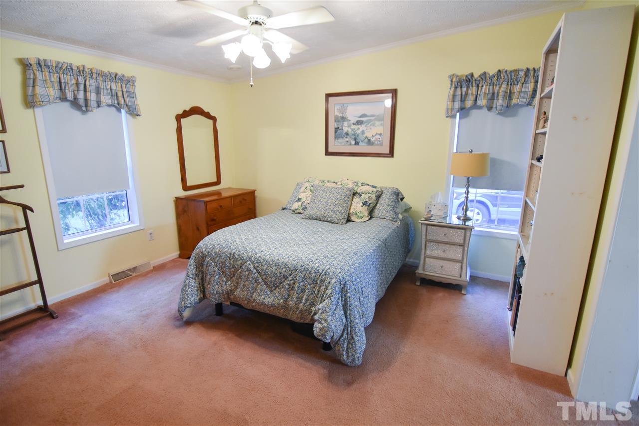 727 Ned Moore Road Timberlake, NC 27583 - Photo 15 of 24 a bedroom with a bed lamps and a large mirror on the dresser