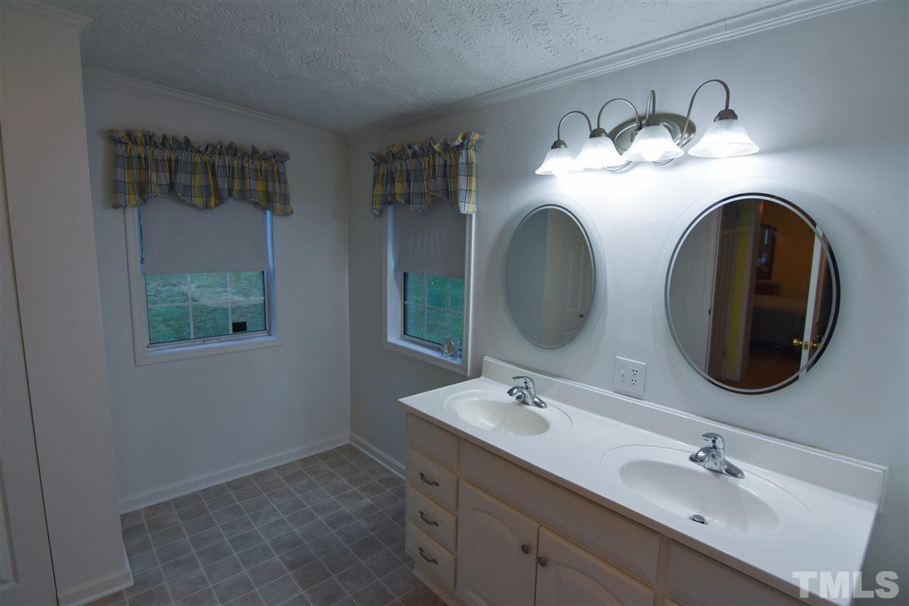 727 Ned Moore Road Timberlake, NC 27583 - Photo 16 of 24 a bathroom with a double vanity sink and a mirror