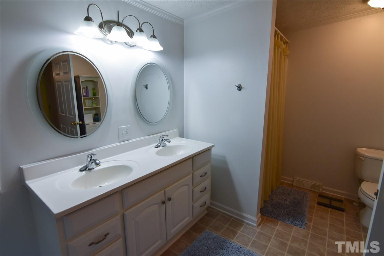 727 Ned Moore Road Timberlake, NC 27583 - Photo 17 of 24 a bathroom with a double vanity sink and a mirror