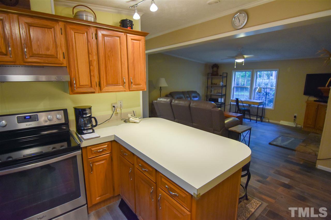 727 Ned Moore Road Timberlake, NC 27583 - Photo 6 of 24 a kitchen with a appliances a sink cabinets and wooden floor
