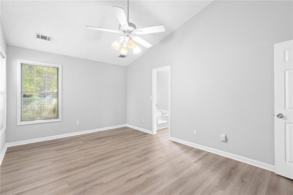 2110 Racquet Club Circle Northwest Lawrenceville, GA 30043 - Photo 21 of 44 an empty room with wooden floor fan and windows