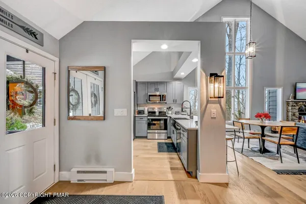 a view of a hall with wooden floor and floor to ceiling window