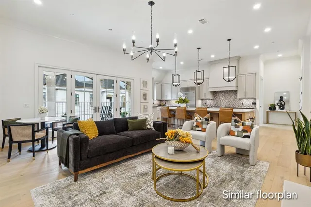 a living room with furniture kitchen view and a chandelier