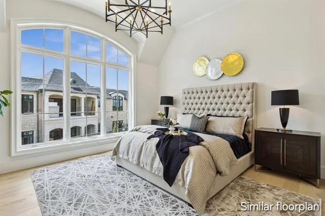 a bedroom with a bed and a chandelier