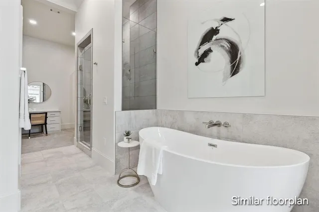 a white bath tub sitting next to a white sink and vanity