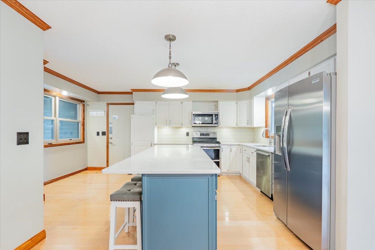 10 Inverness Drive Bloomington, IL 61701 - Photo 12 of 43 a kitchen with stainless steel appliances kitchen island granite countertop a refrigerator a stove and a sink with wooden floor