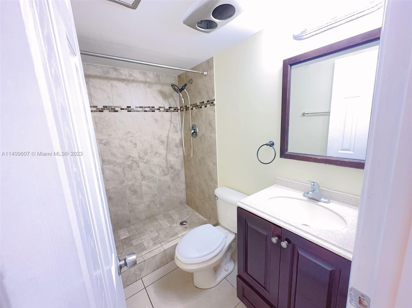 22615 Southwest 66th Avenue, Unit 216 Boca Raton, FL 33428 - Photo 13 of 23 a bathroom with a sink a toilet a mirror and shower