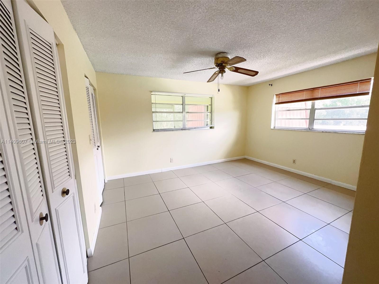 22615 Southwest 66th Avenue, Unit 216 Boca Raton, FL 33428 - Photo 20 of 23 an empty room with windows and fan