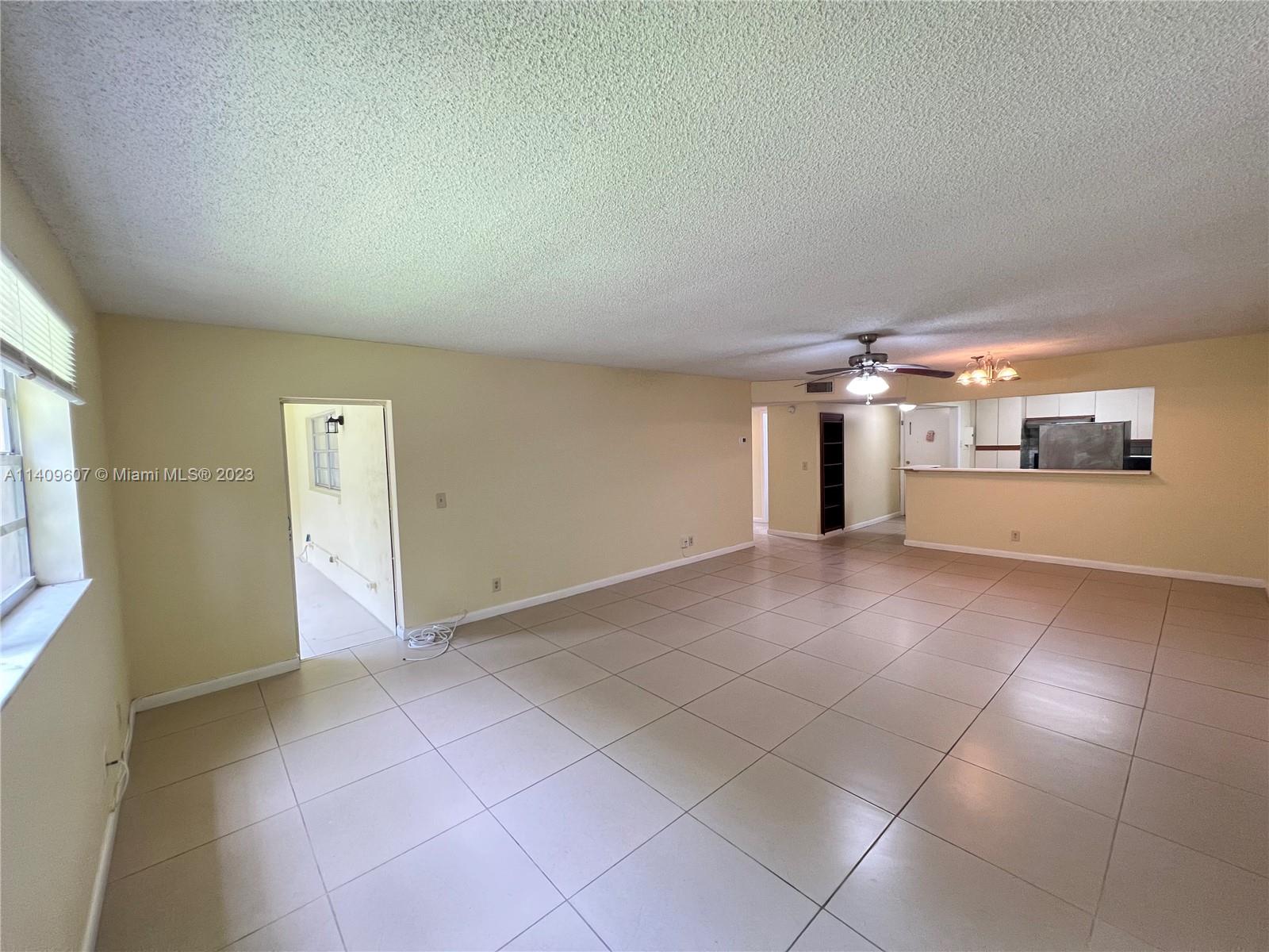 22615 Southwest 66th Avenue, Unit 216 Boca Raton, FL 33428 - Photo 5 of 23 a view of a big room with windows and chandelier