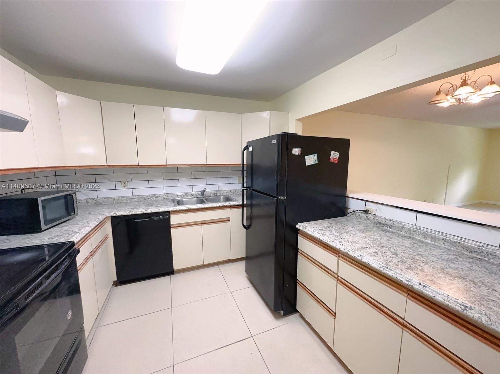 22615 Southwest 66th Avenue, Unit 216 Boca Raton, FL 33428 - Photo 6 of 23 a kitchen with a sink a stove and refrigerator
