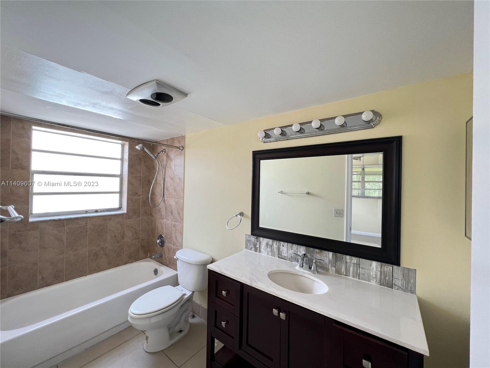 22615 Southwest 66th Avenue, Unit 216 Boca Raton, FL 33428 - Photo 8 of 23 a bathroom with a toilet sink and mirror