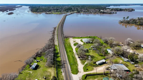 an aerial view of a residential houses with outdoor space and lake view