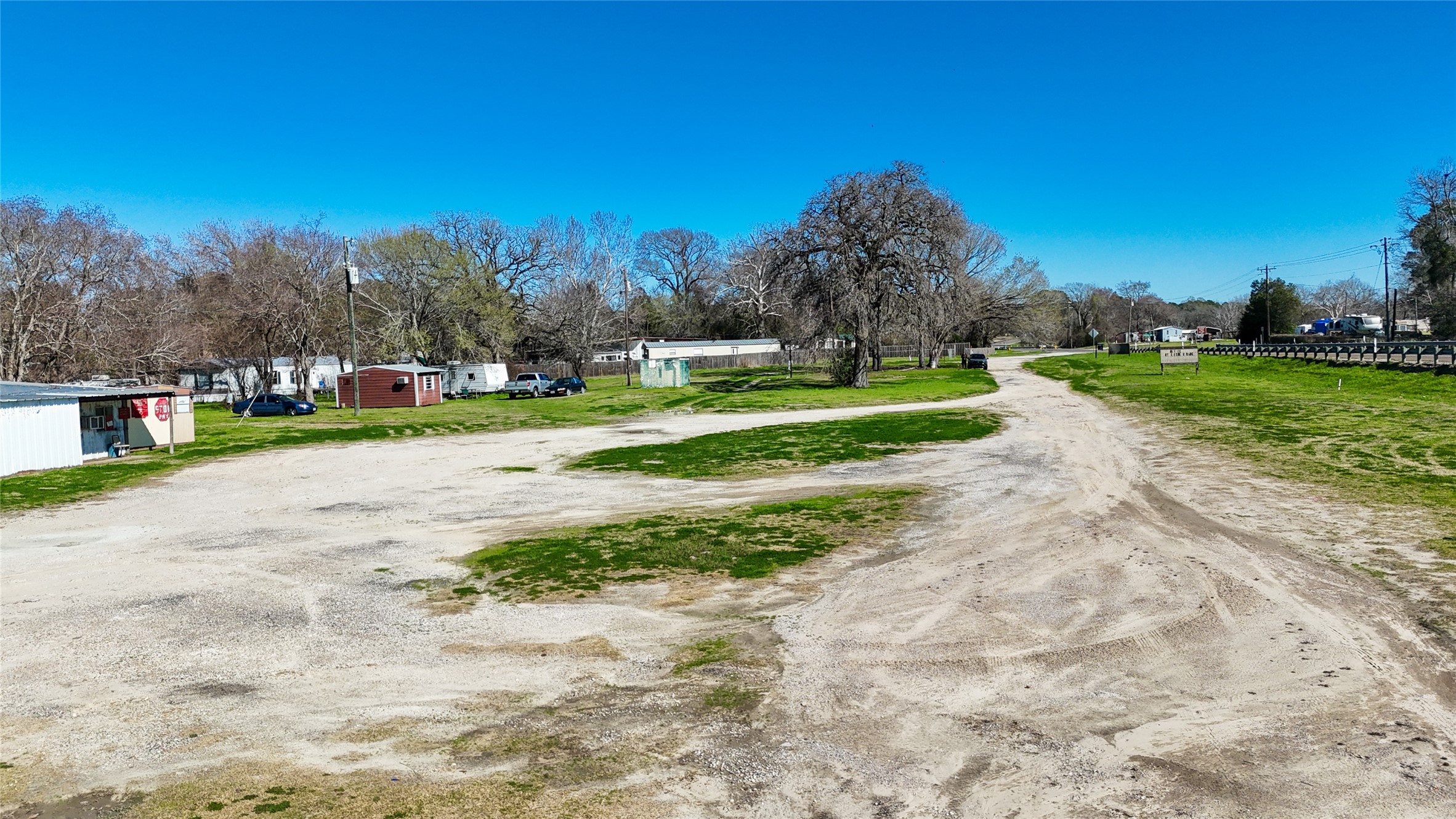 224 Steinback Avenue Trinity, TX 75862 - Photo 10 of 23 a view of a park with large trees and cars parked in front of it