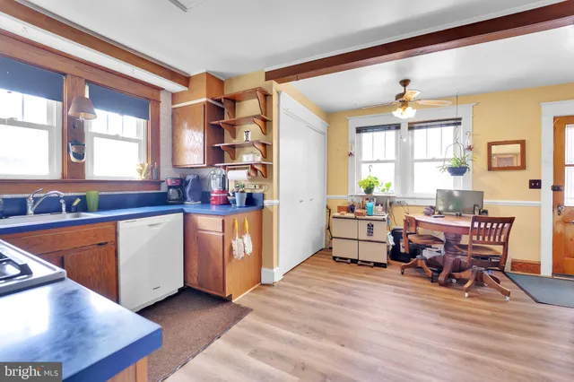 a living room with stainless steel appliances kitchen island granite countertop furniture and a wooden floor