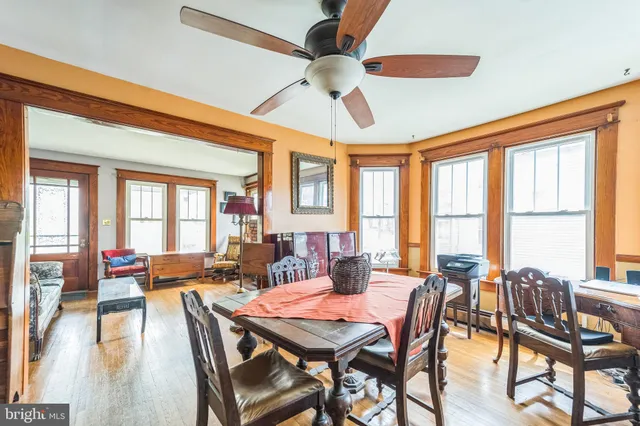 a dining room with furniture a chandelier and wooden floor