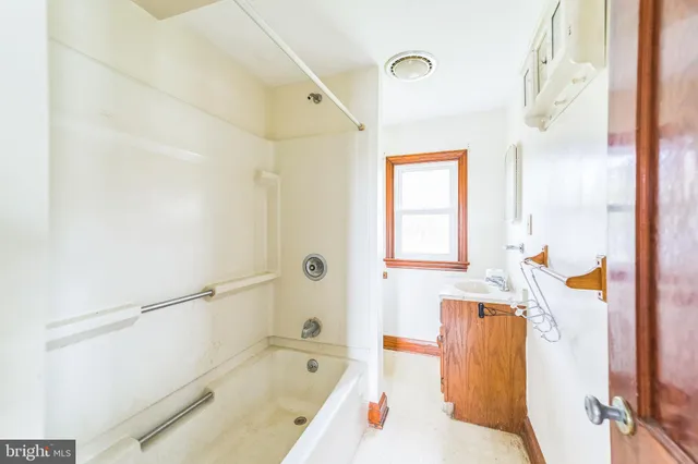 a bathroom with a tub sink and mirror