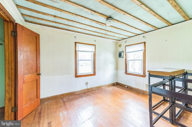 a view of empty room with windows and wooden floor
