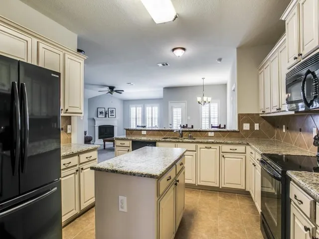 a kitchen with stainless steel appliances granite countertop a stove refrigerator sink and cabinets