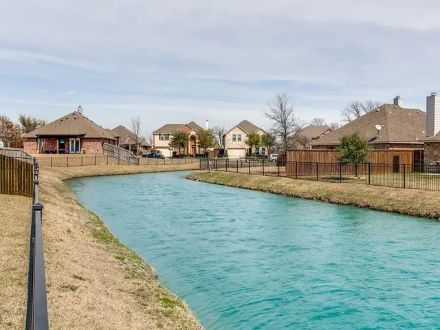 a view of a house with yard and lake view