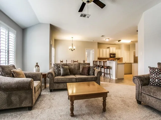 a living room with furniture and kitchen view