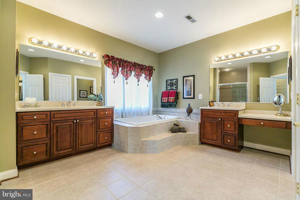 604 Clear Spring Road Great Falls, VA 22066 - Photo 16 of 28 a spacious bathroom with a tub sink and mirror
