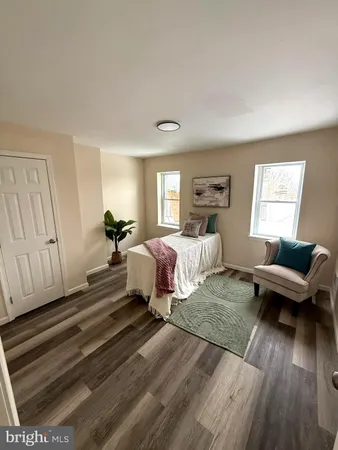 a spacious bedroom with a bed and wooden floor