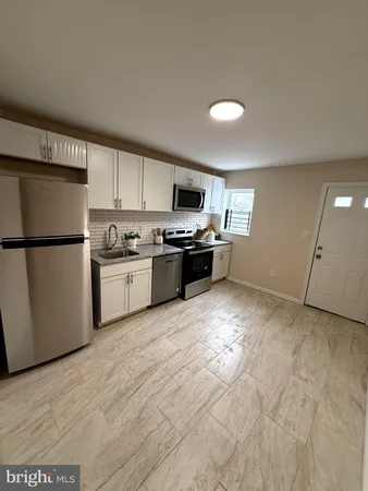 a kitchen with stainless steel appliances granite countertop a refrigerator sink and white cabinets