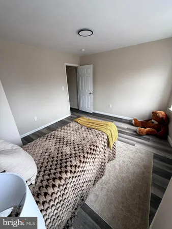 a bedroom with bed and wooden floor