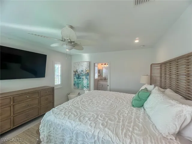 a spacious bedroom with a large bed and a flat screen tv