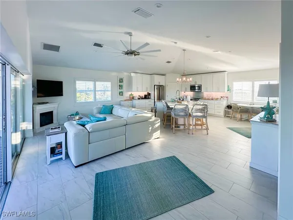 a dining room with furniture a chandelier and kitchen view