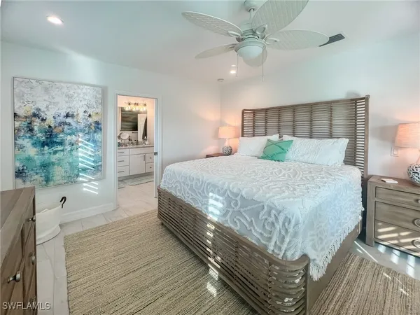 a bedroom with a large bed and a chandelier