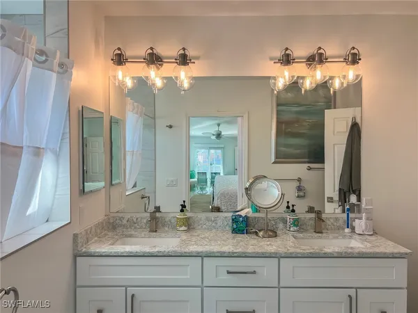 a bathroom with a granite countertop sink and a mirror