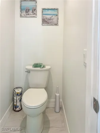 a white toilet sitting next to a white wall