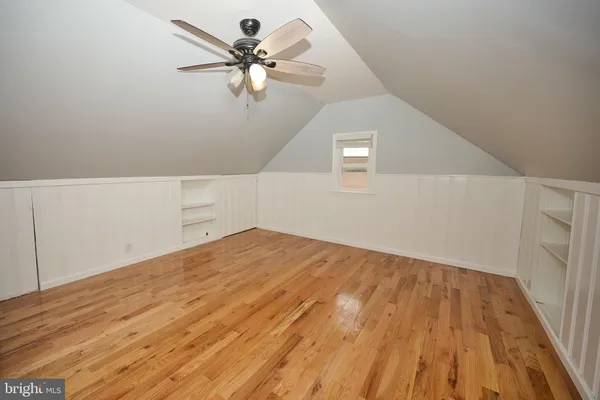 a view of a big room with wooden floor and a ceiling fan
