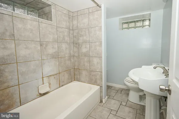 a bathroom with a sink a toilet and bathtub
